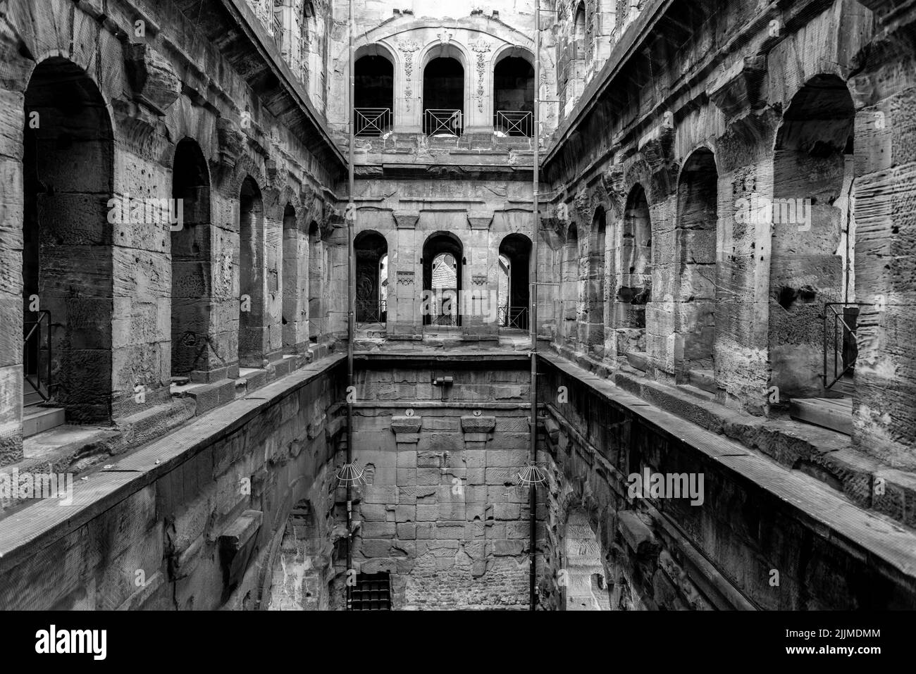 A grayscale image of the ancient Porta Nigra Roman city gate walls from the inside, in Trier, Germany Stock Photo