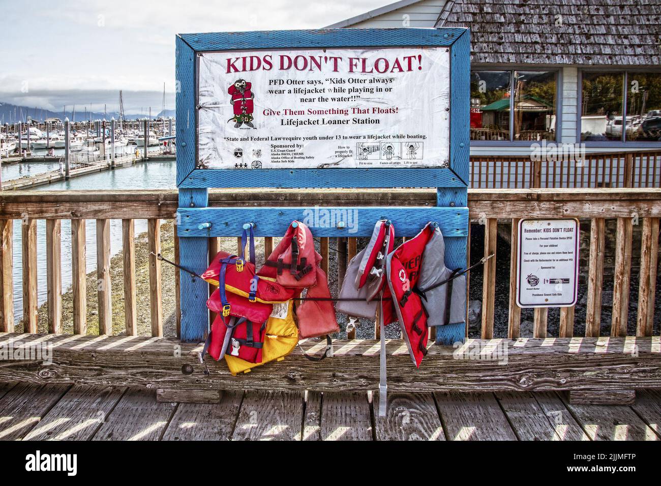 2022 06a-24 Seward Alaska USA - Kids Don't Float sign on dock walkway with loaner Childrens lifejackets hanging below Stock Photo