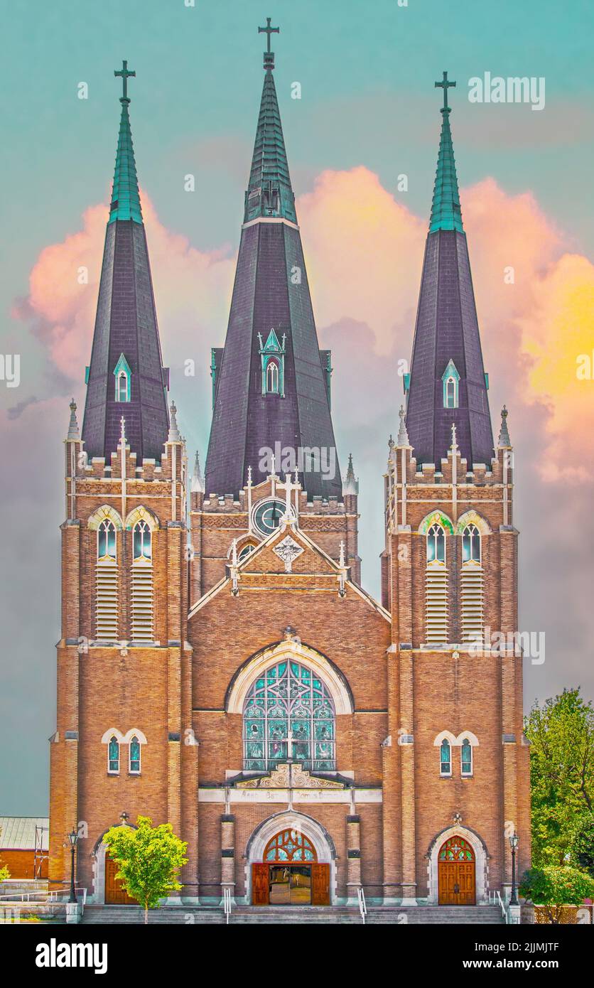 Catholic Church with copper steeples and stained glass in downtown Tulsa under sunset sky Stock Photo