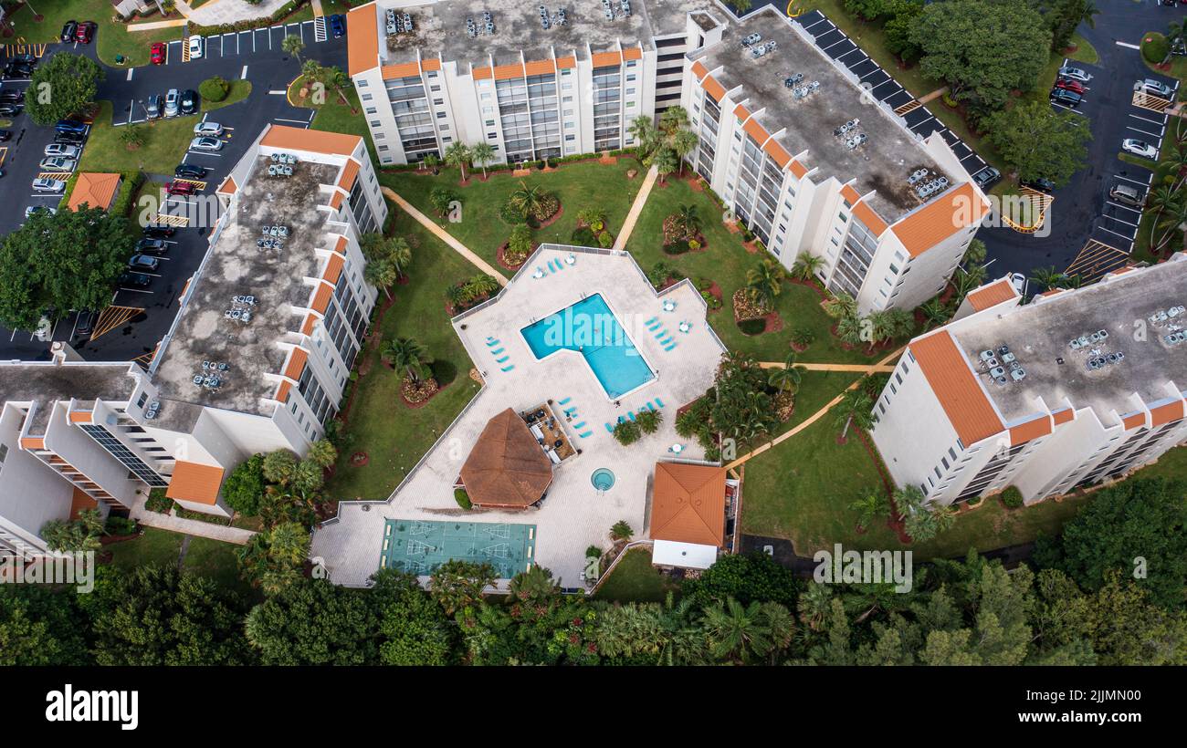 An aerial shot over a swimming pool in an apartment complex on a sunny