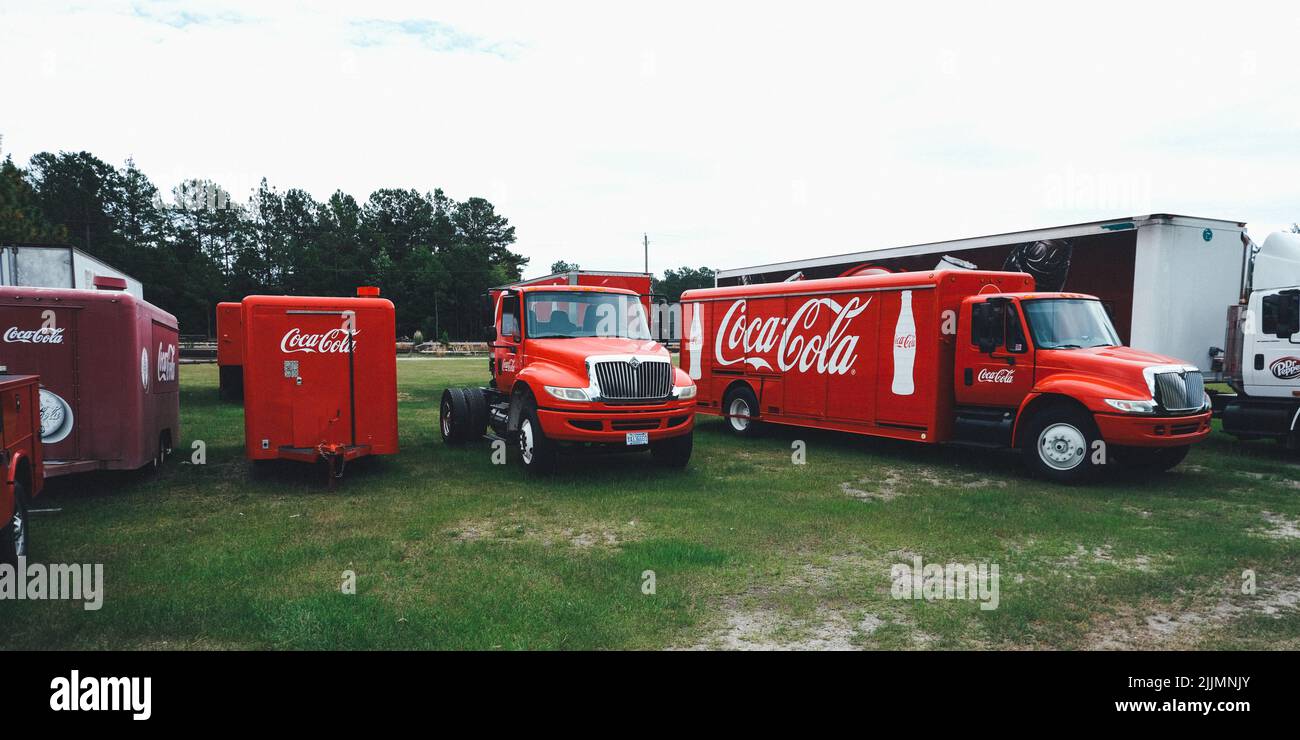 Coca Cola delivery trucks sit in a yard waiting to get to work Stock Photo
