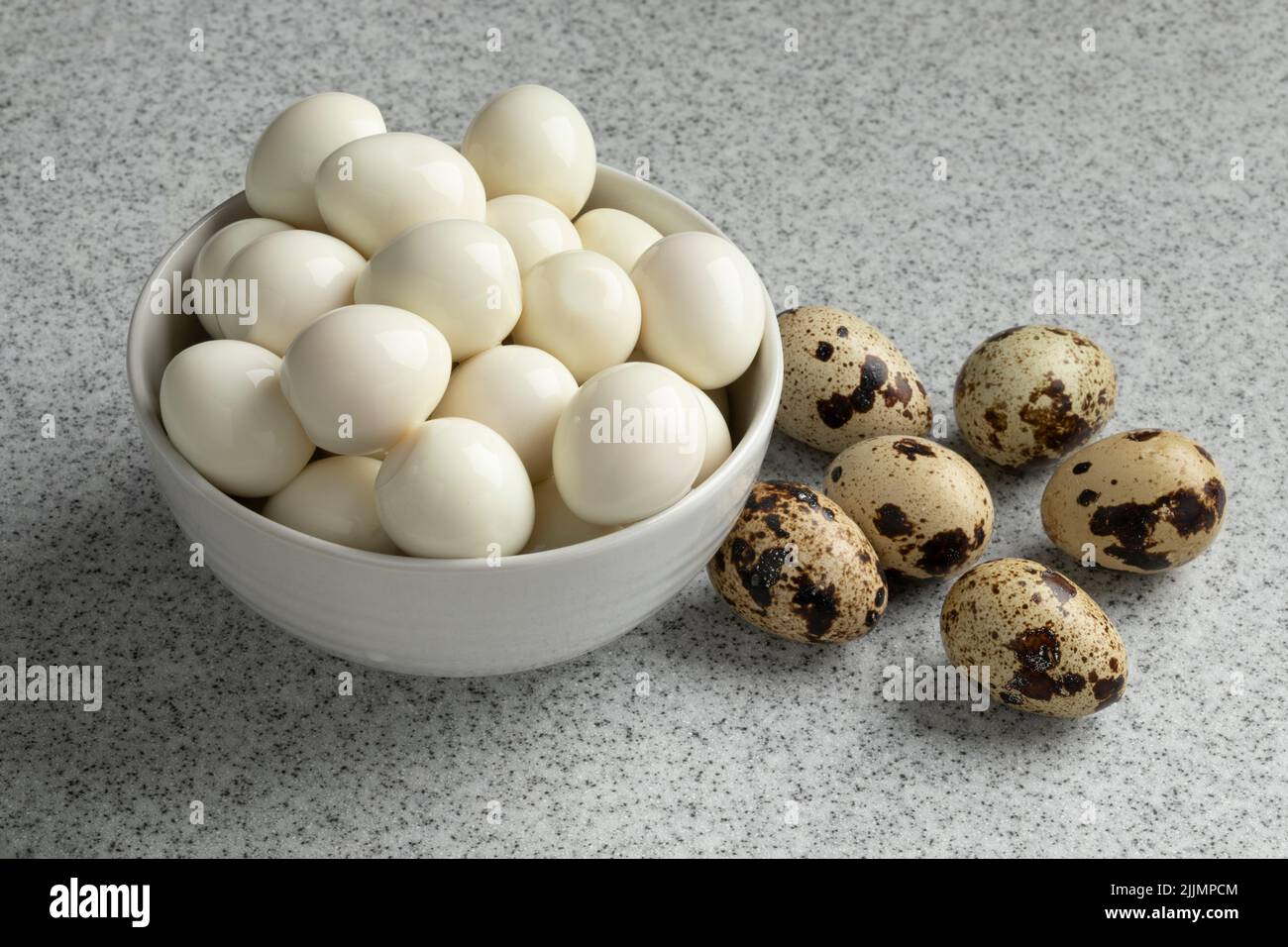 Cooked and fresh raw Quail eggs close up Stock Photo