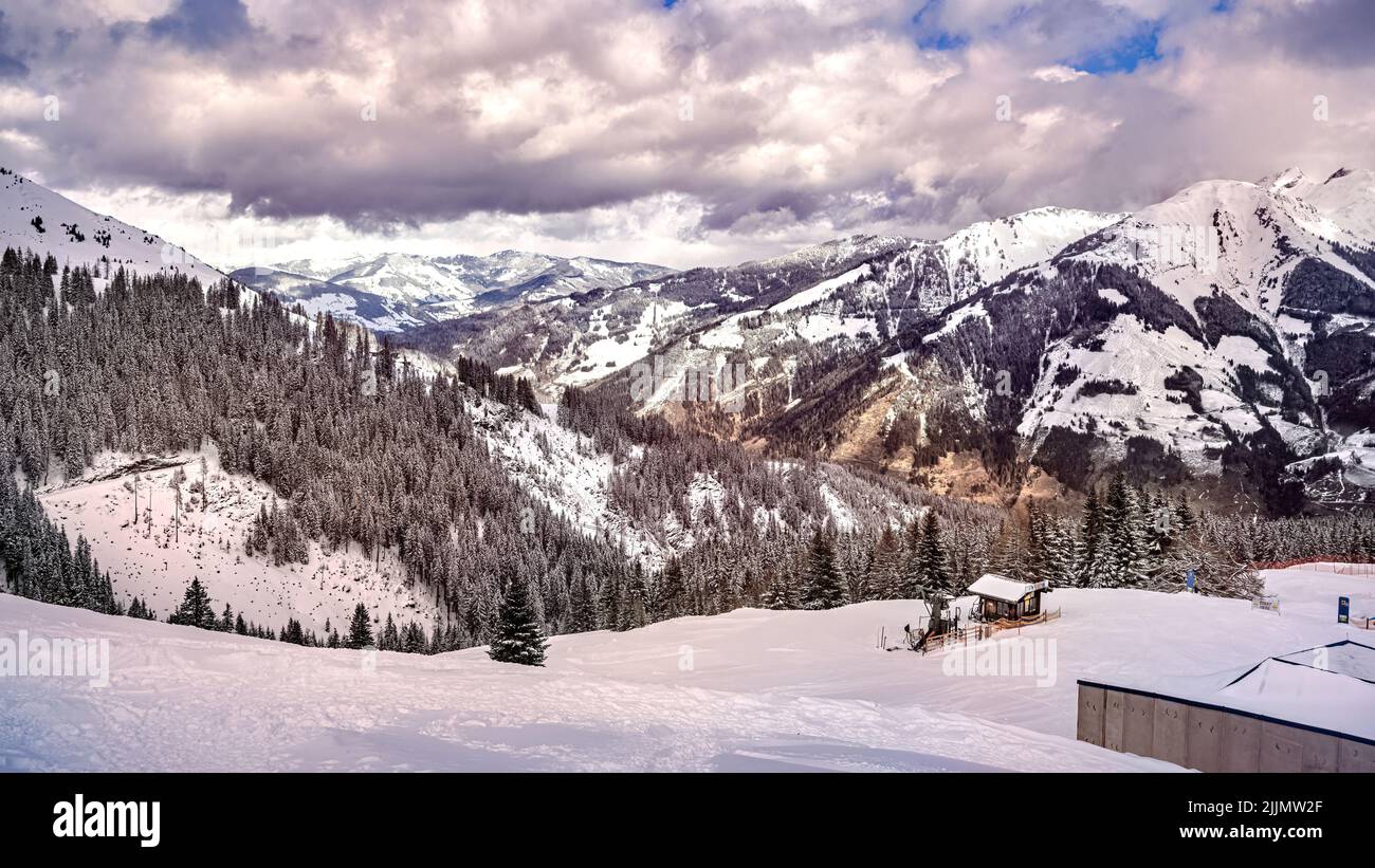 A beautiful scene of snowy Mountains in the Alps, ski center Rauris, Austria with dramatic cloudy sky Stock Photo