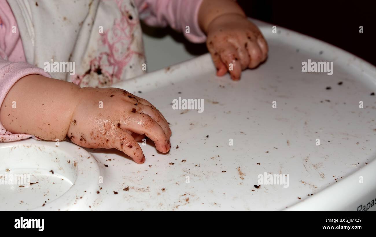 Baby dirty hands which eating cookies Stock Photo