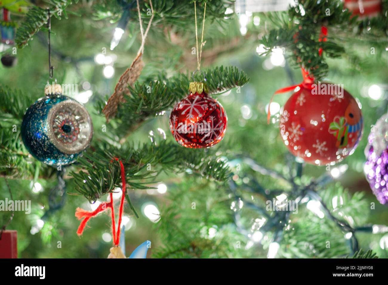 A closeup of setting up the Christmas tree with red and blue ornaments and lights Stock Photo