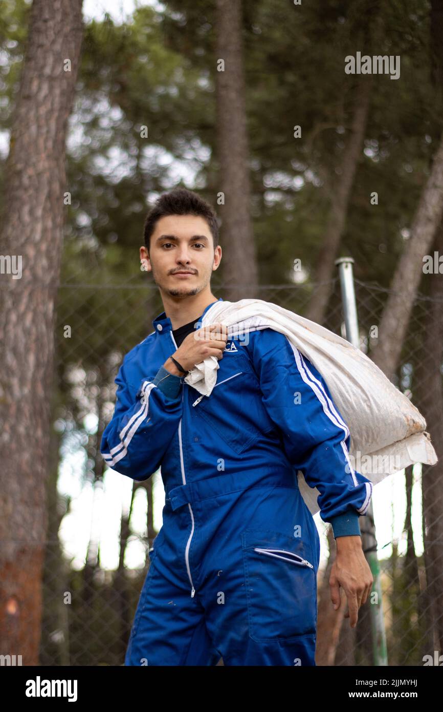 A portrait of a young male veterinarian in blue uniform carrying a textile bag on his shoulder Stock Photo