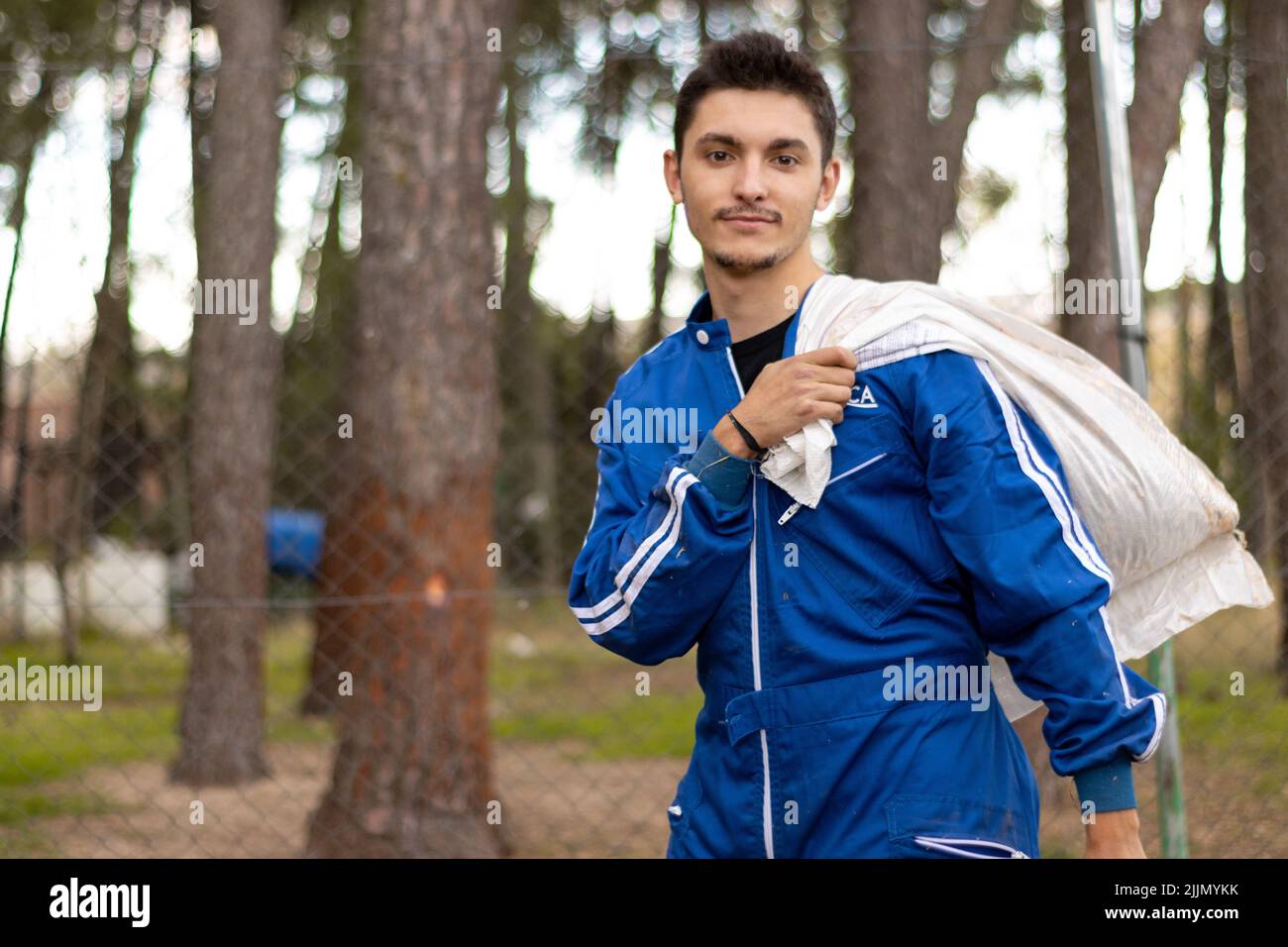 A portrait of a young male veterinarian in blue uniform carrying a textile bag on his shoulder Stock Photo