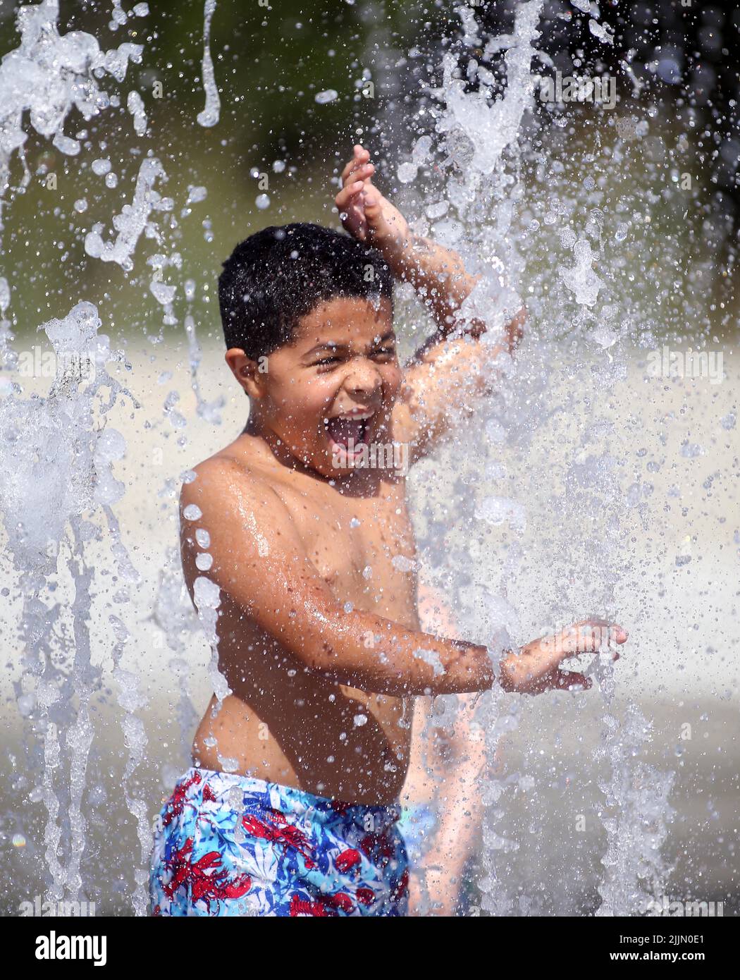 Raleigh, North Carolina, USA. 27th July, 2022. 8yearold AYDEN GREEN cools off by running