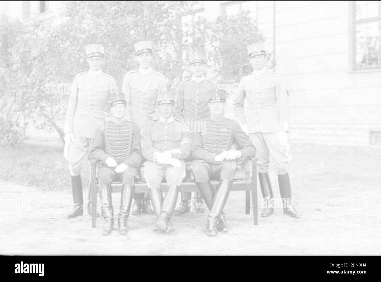 Sub -commander from K 1 Stockholm, who has undergone the arm's sub -officer school. (Three -recorded furir) together with six students in uniform m/ä. Four students (standing) from K 1 Stockholm and two students (sitting) from K 2, Hälsingborg. To the left of the image aspirant d'otrante. The bright K 1 uniforms privately sewn. The dark uniforms crown. Group picture. Stock Photo