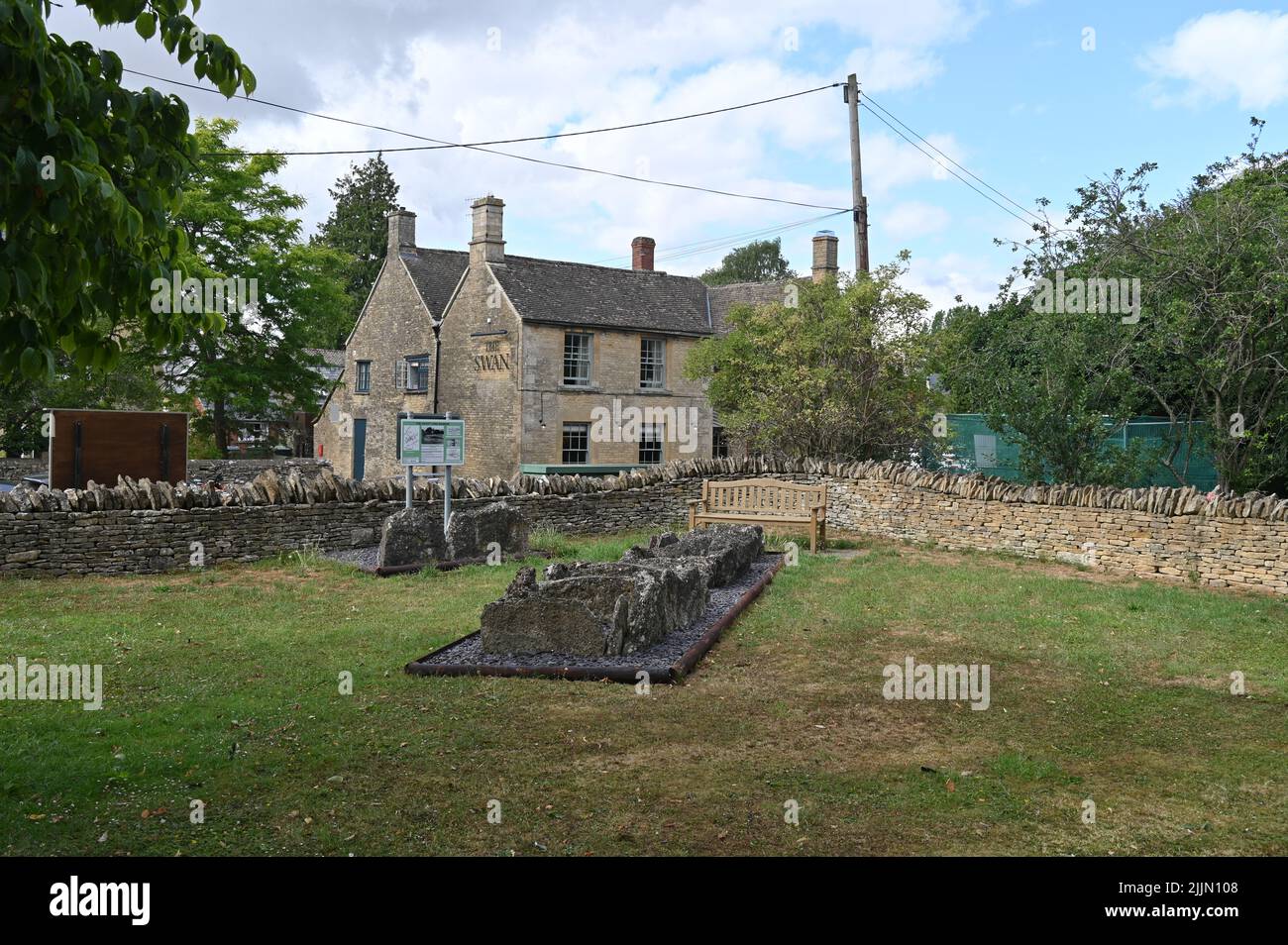 Village Pound in the Oxfordshire village of Ascott under Wychwood with the village public house The Swan in the rear. The stones are a memorial to the Stock Photo