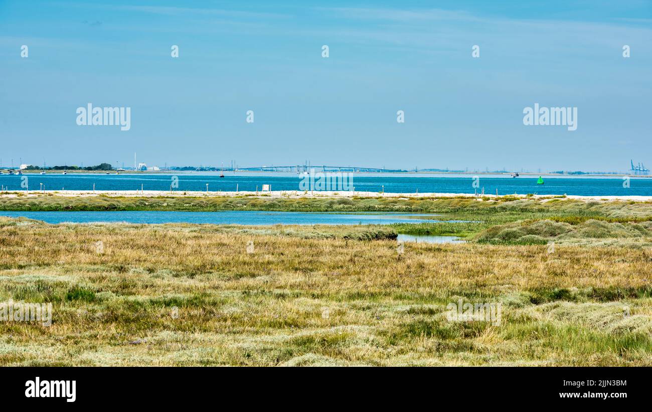 View across the swale estuary towards the Isle of Sheppey and the KingsFerry bridge in Kent, England Stock Photo
