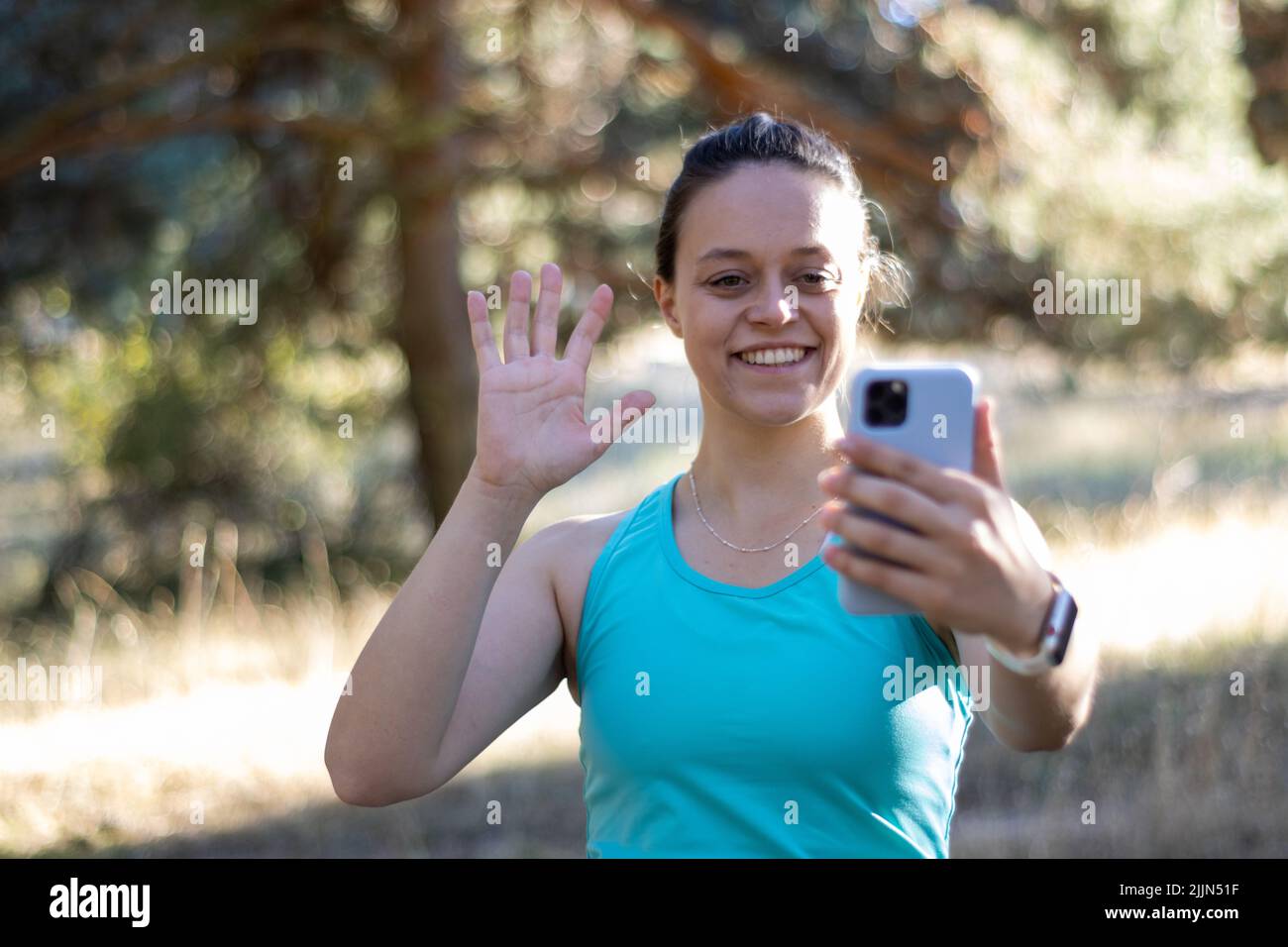 A smiling woman talking during a video call with a smartphone Stock Photo