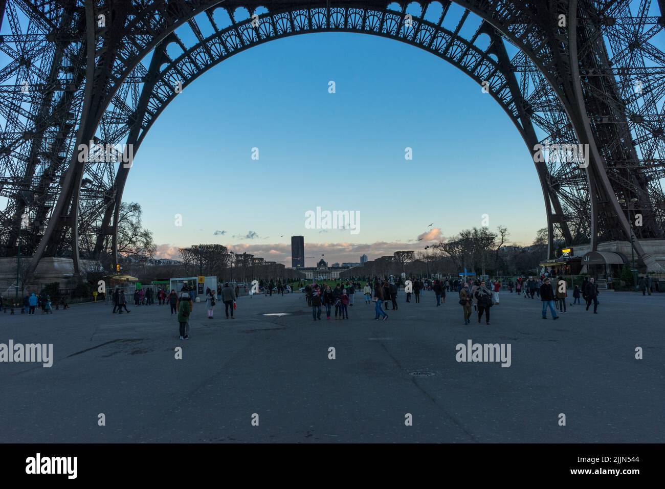 Some tourists standing under the Eiffel tower in Paris. Stock Photo
