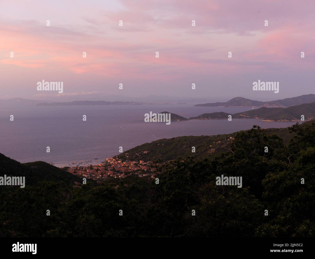 The beautiful landscape with the green hills and the sea at sunset ...