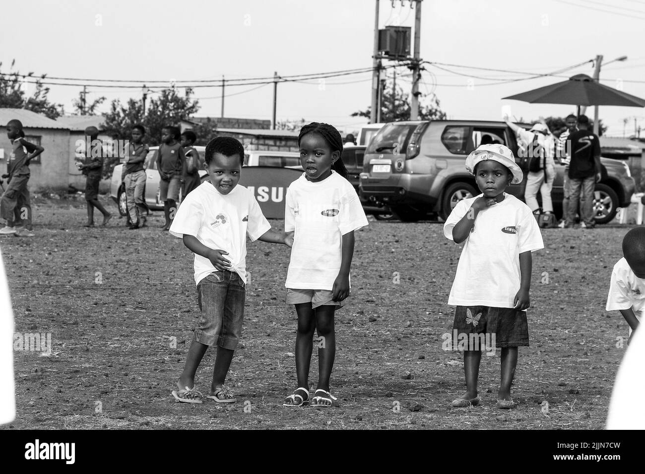 A grayscale of African children doing soccer related activities on the school playground in Johannesburg, South Africa Stock Photo
