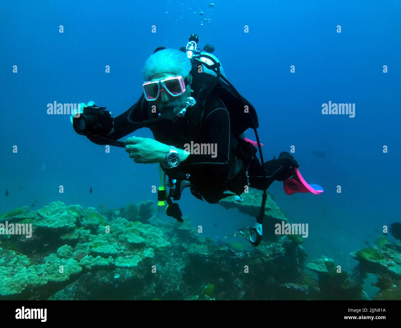 Senior man scuba diving in the Mu Ko Similan National Park and taking a photo, Similan Islands, Thailand Stock Photo