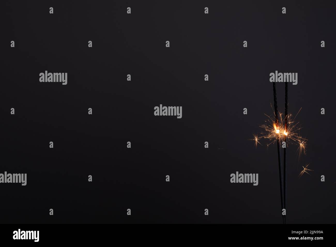 A wallpaper of couple bengal lights sparkling with black background Stock Photo