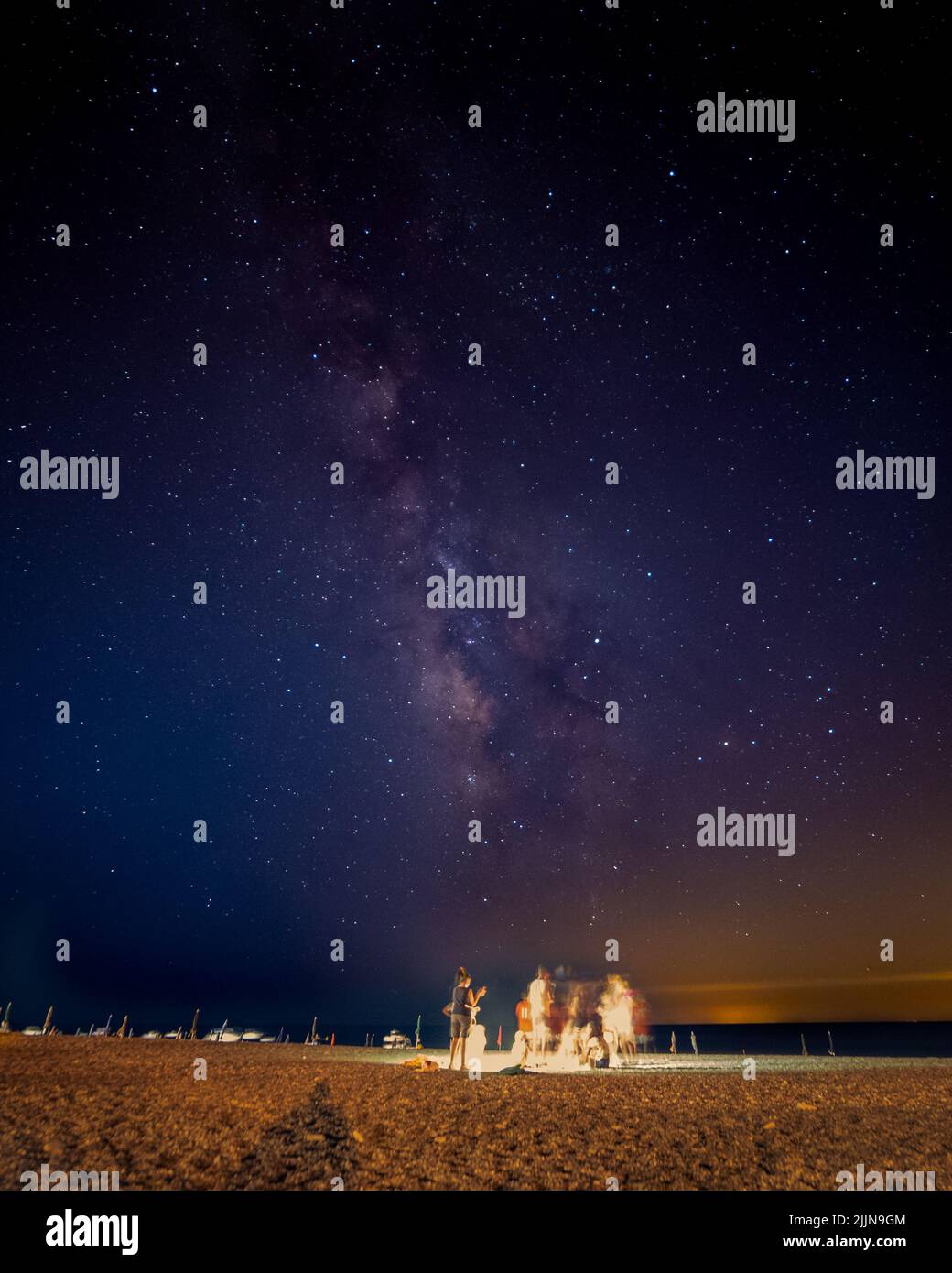 A vertical shot of the Milky Way in the night sky above the beach Stock ...