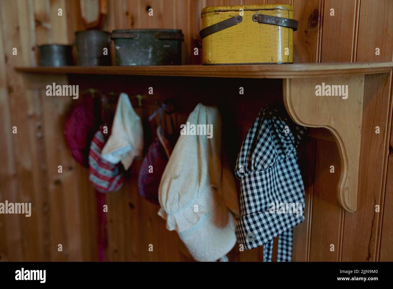 The old vintage hats and tin lunch boxes are hung onto a wooden shelf. Stock Photo