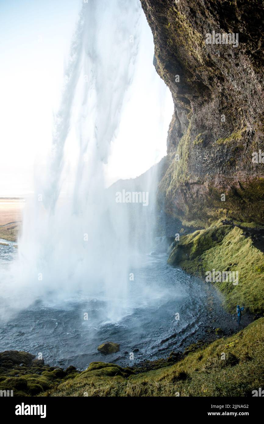 A scenic view of Seljalandsfoss waterfall against blue sky on a sunny day in the South Region in Iceland Stock Photo
