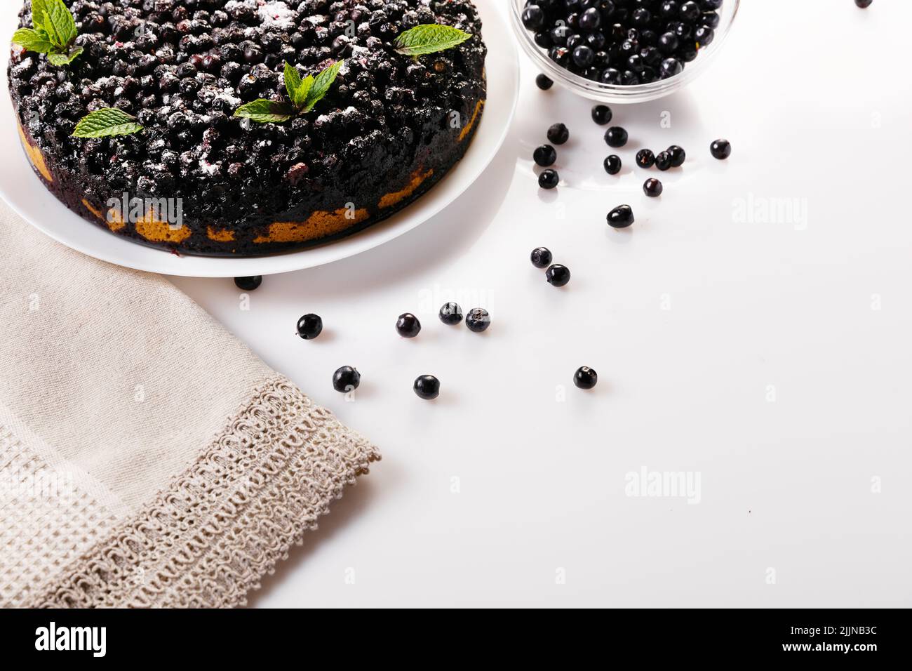 Blueberry pie with mint on a white plate on a white background, top view horizontal close-up Stock Photo