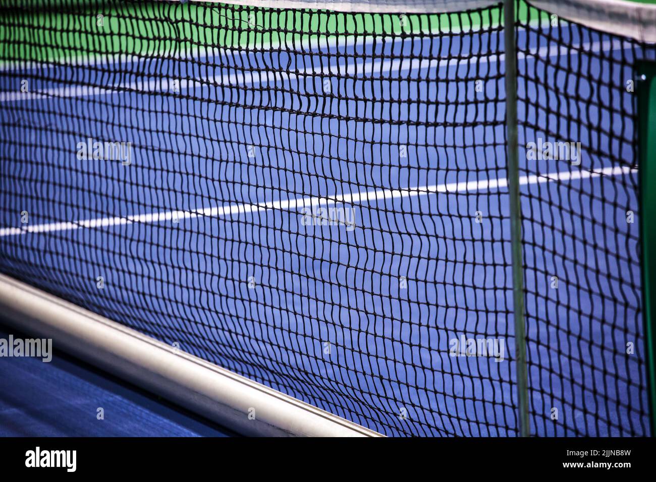 A closeup of a tennis net in an empty court Stock Photo