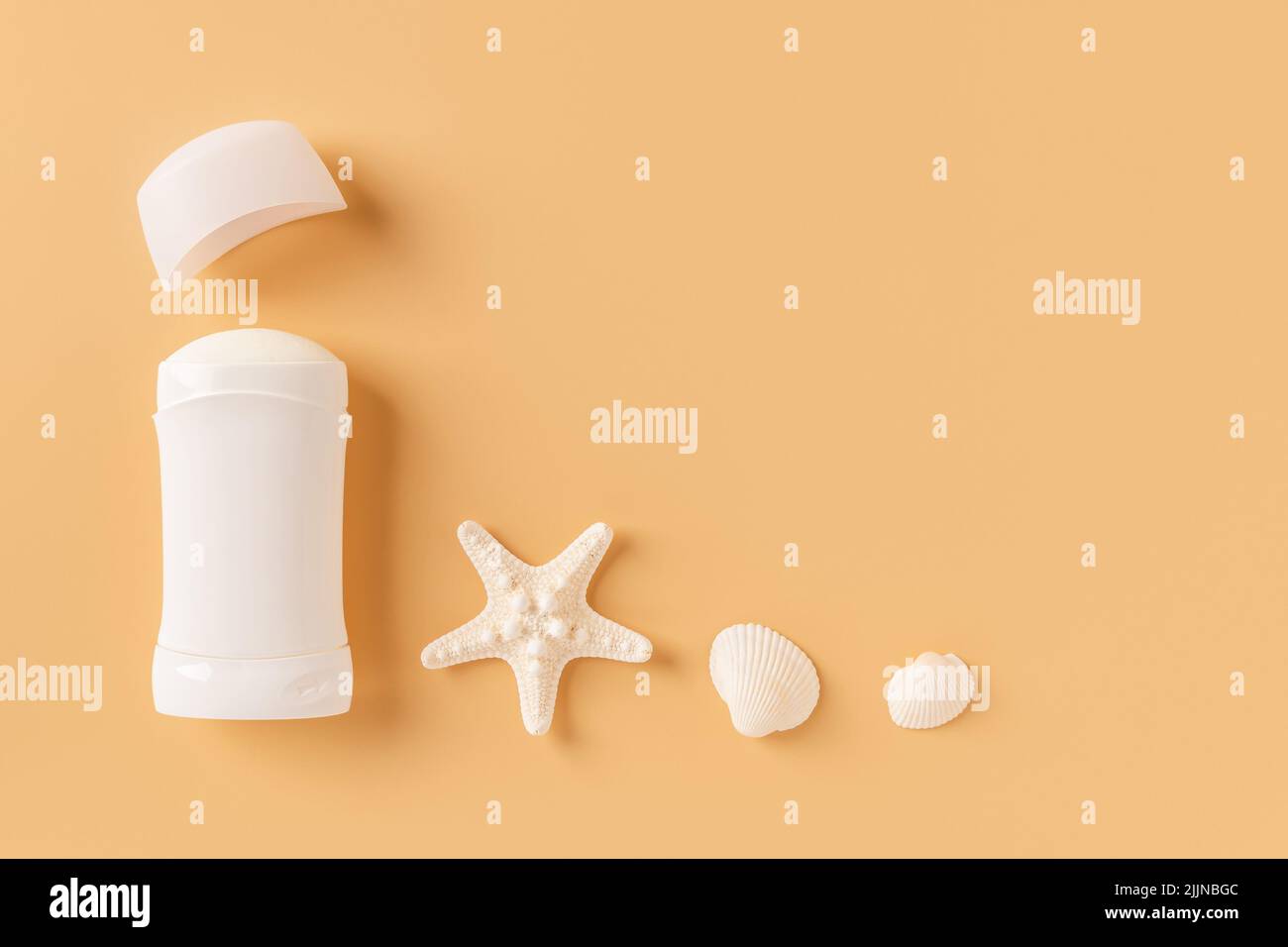 Open solid deodorant antiperspirant, sea star and shells on a pastel orange background. Natural sea mineral toiletries and organic cosmetics concept. Stock Photo