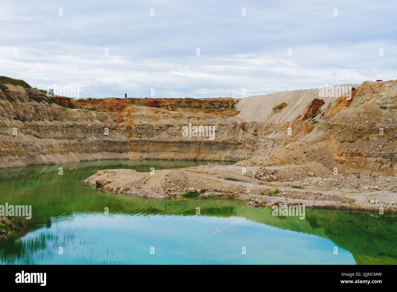 Lake formation in an old abandoned quarry. Quarry lake. Crushed stone dumps in a closed area for