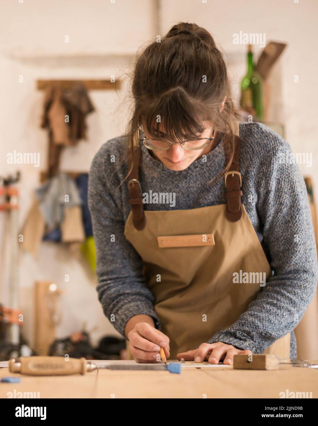 A young girl designing a new home furniture piece crafting out of timber Stock Photo