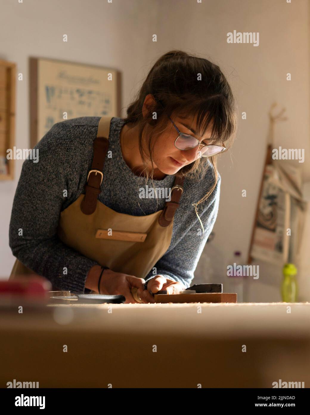 A young girl designing a new home furniture piece crafting out of timber Stock Photo
