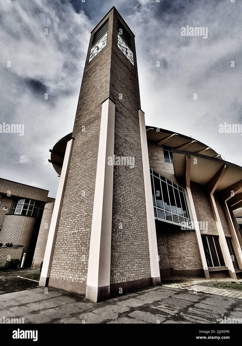 A low angle shot of an brick tower with a clock in vertical Stock Photo ...