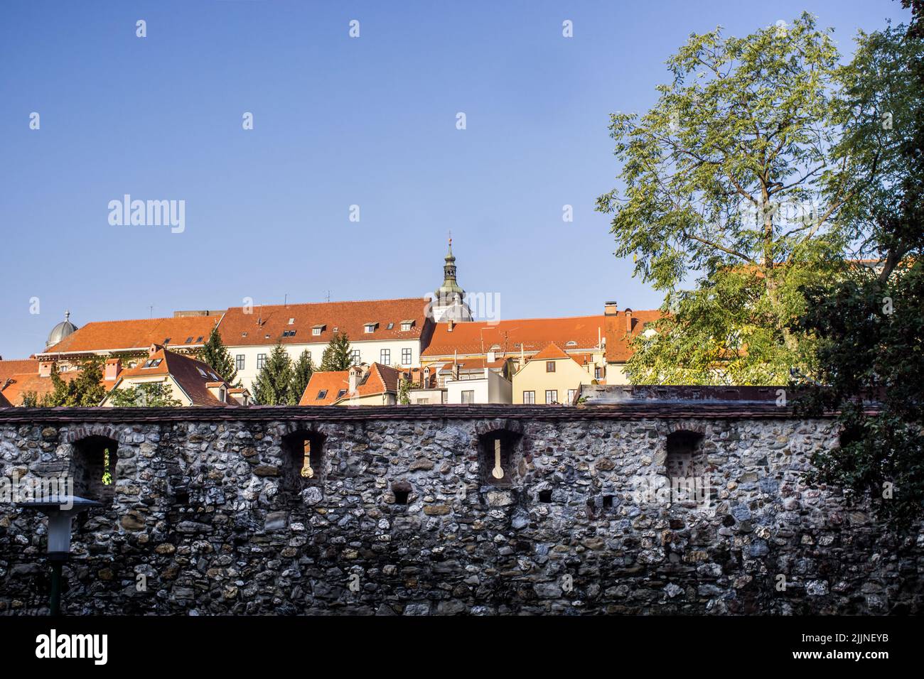 An old stone wall with windows against the buildings Stock Photo - Alamy