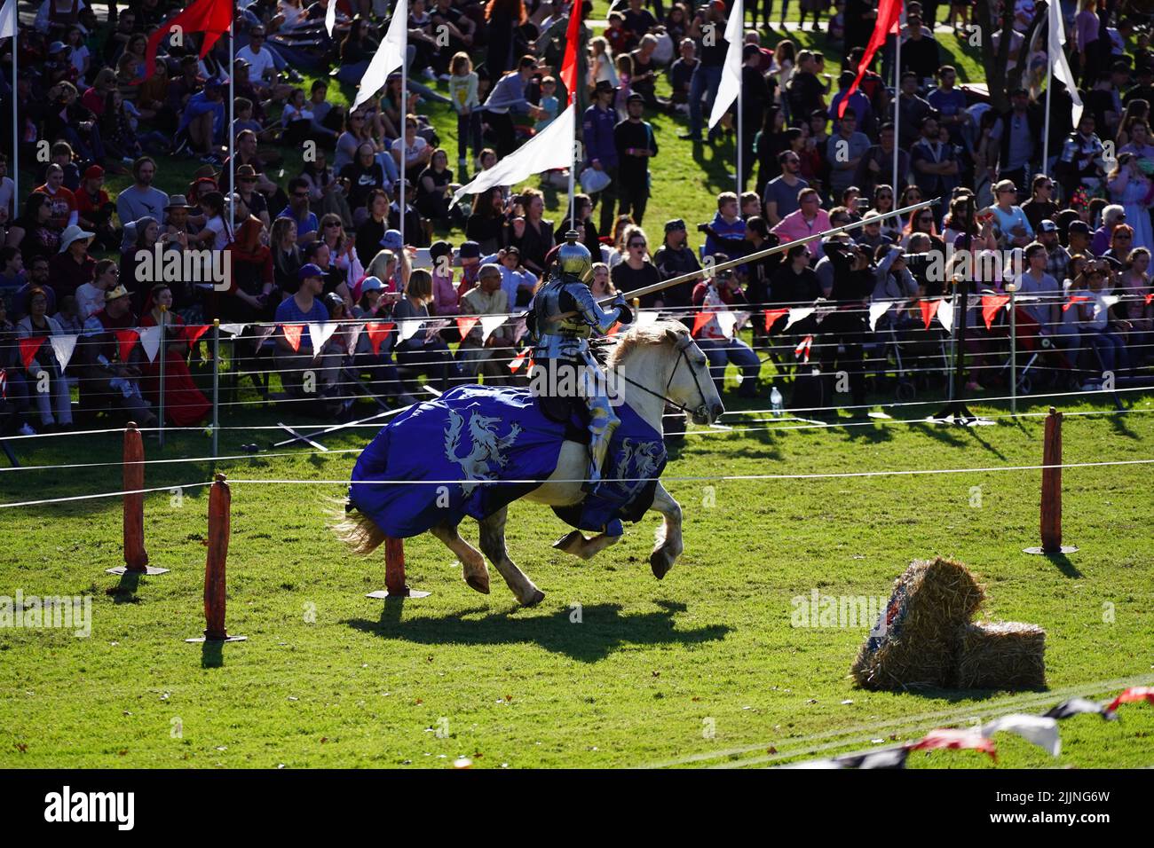 A jousting on horse in background of public at Blacktown Medieval Fayre