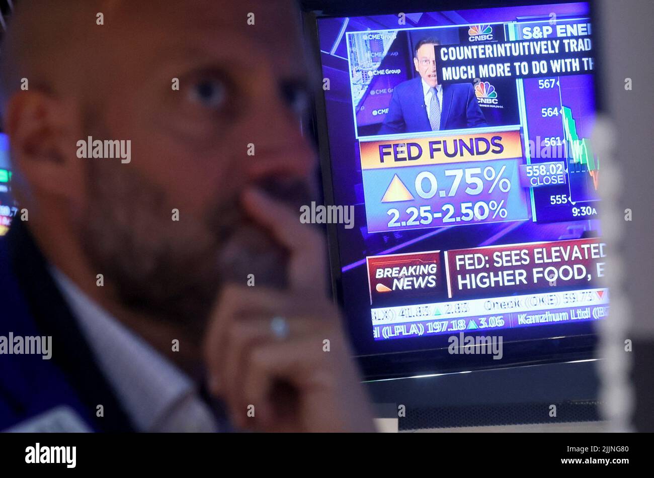 A screen displays the Fed rate announcement as a trader reacts on the floor of the New York Stock Exchange (NYSE) in New York City, U.S., July 27, 2022. REUTERS/Brendan McDermid Stock Photo