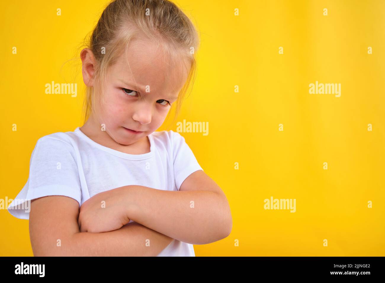 cute angry unsatisfied pre school girl arms crossed expressing disagreement Stock Photo