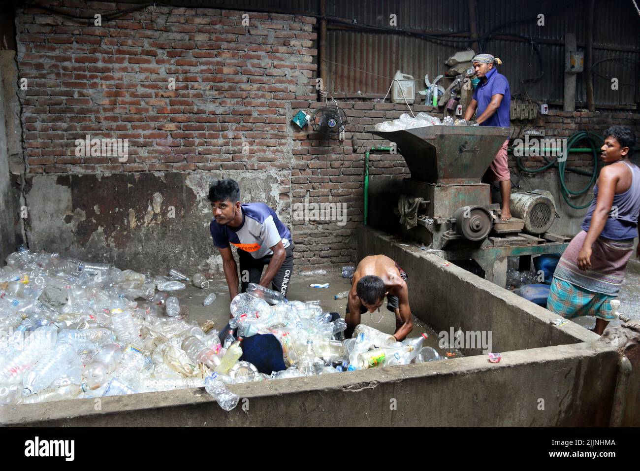 Workers are seen in a plastic bottle recycling factory in Dhaka
