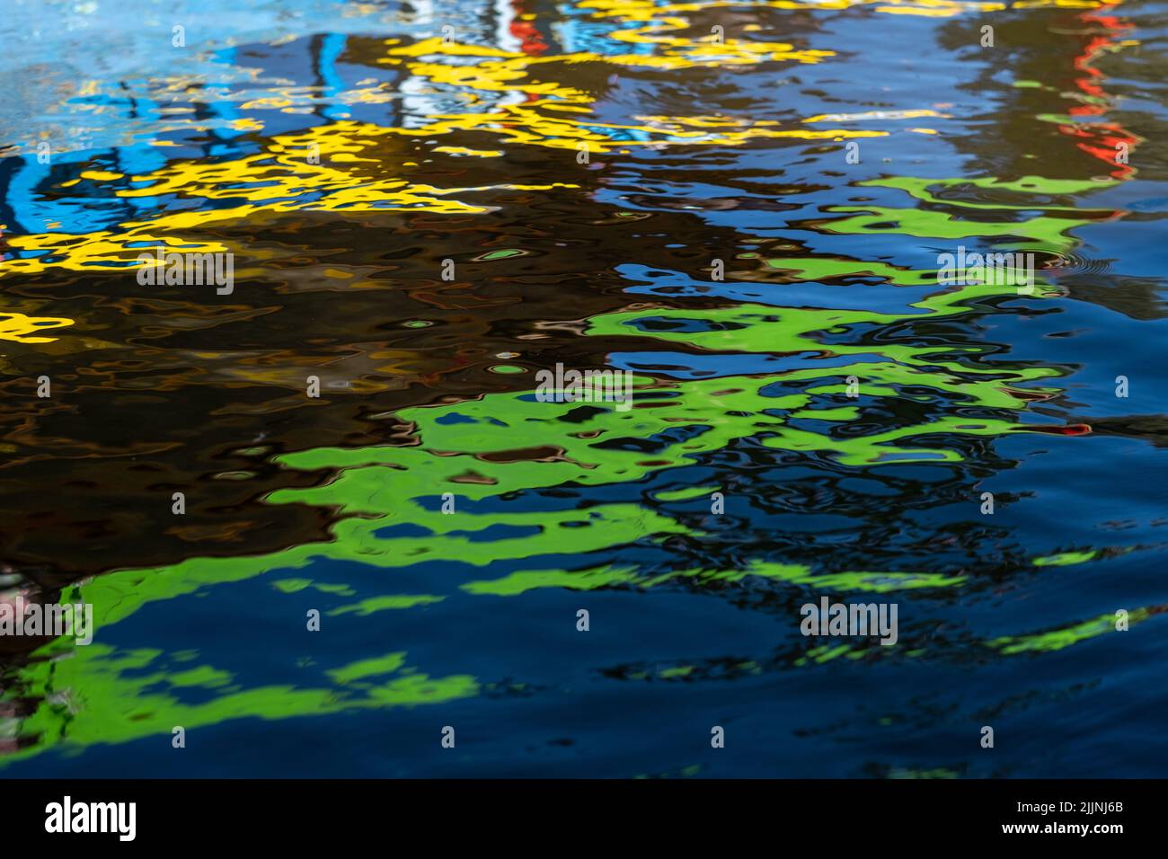 Abstract reflections of the colorful trajinera boats on the water of a canal in Xochimilco, in Mexico City Stock Photo