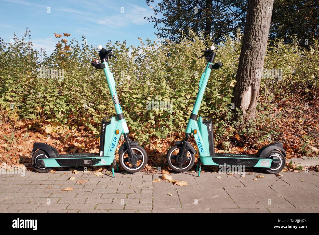 A scenic shot of scooters parked around the grass in Bielefeld, Germany Stock Photo