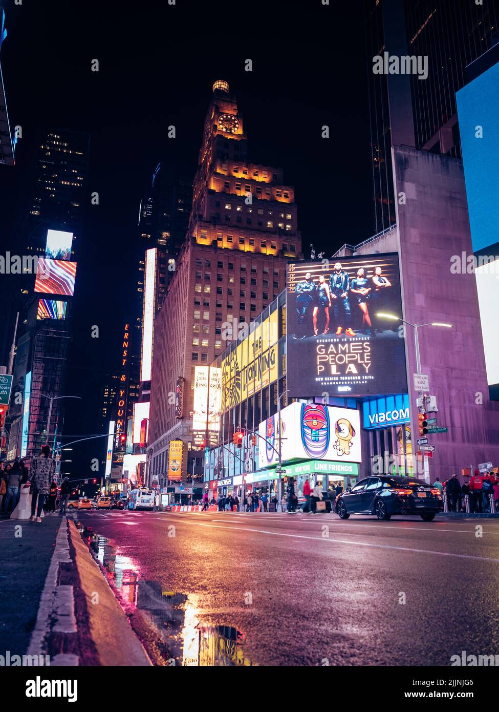 A vertical shot of the nightlife in New York City streets with the buzz