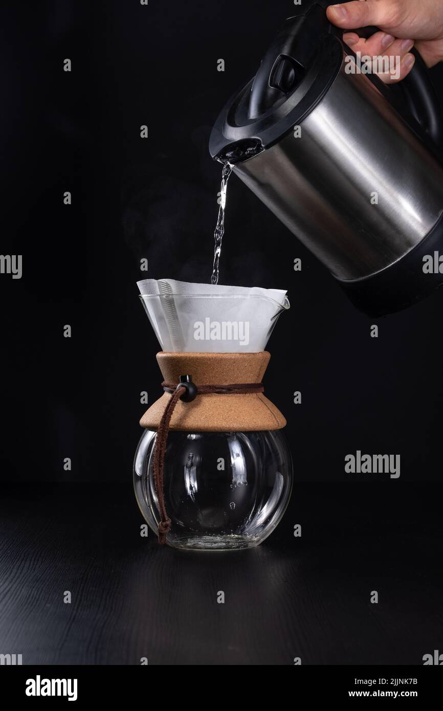 https://c8.alamy.com/comp/2JJNK7B/a-vertical-closeup-of-the-pouring-boiling-water-into-the-coffee-maker-2JJNK7B.jpg