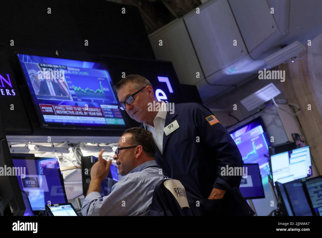 Traders react on the floor of the New York Stock Exchange (NYSE) as a screen shows Federal Reserve Board Chairman Jerome Powell during a news conference following a Fed rate announcement, in New York City, U.S., July 27, 2022. REUTERS/Brendan McDermid Stock Photo