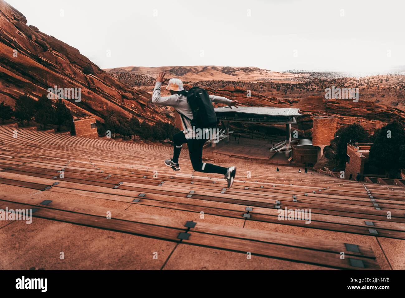 A guy running on the bleachers of the Red Rocks Amphitheatre in