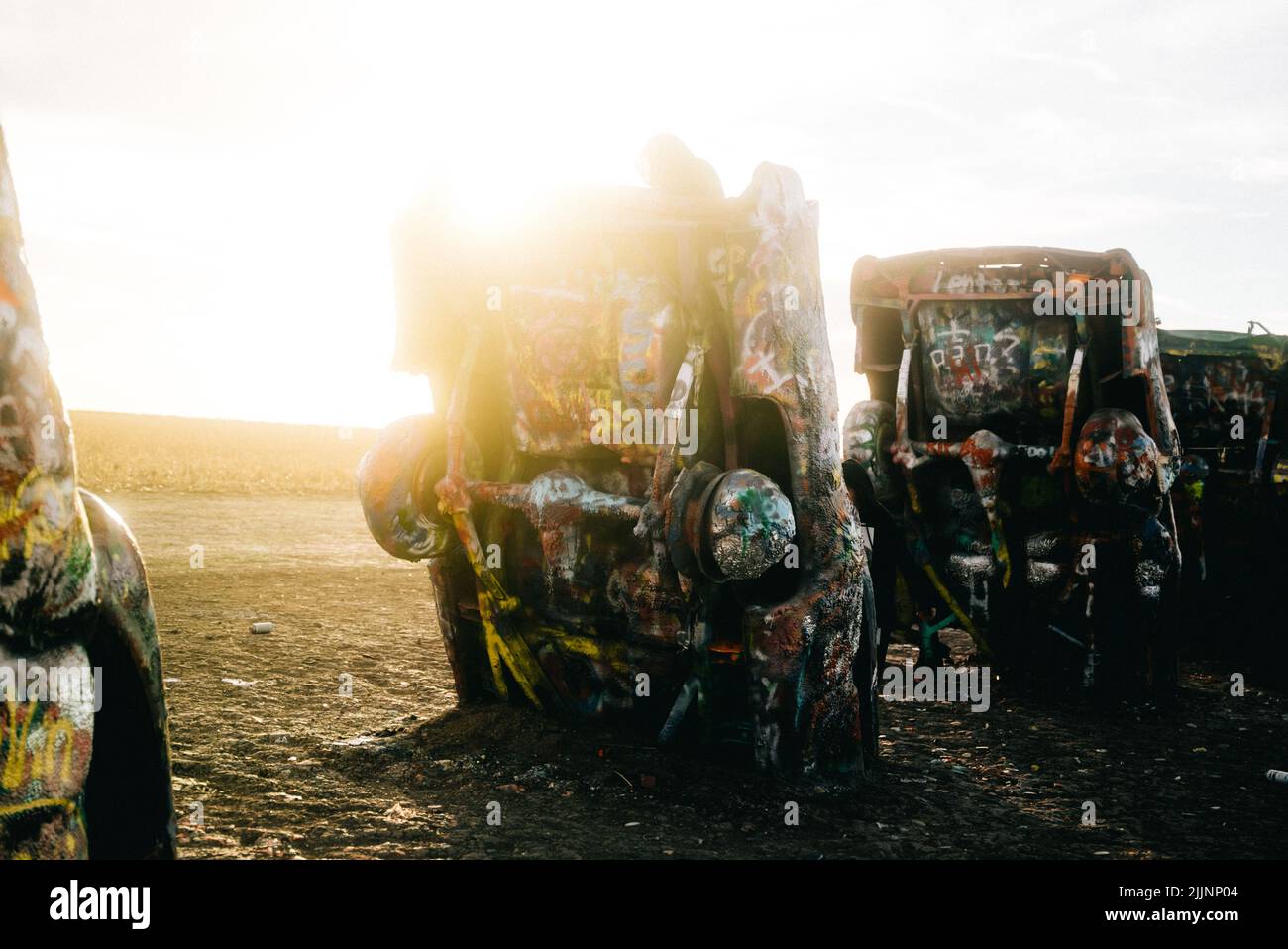 A row of colorful cars at Cadillac Ranch in Amarillo, Texas against a bright sky Stock Photo