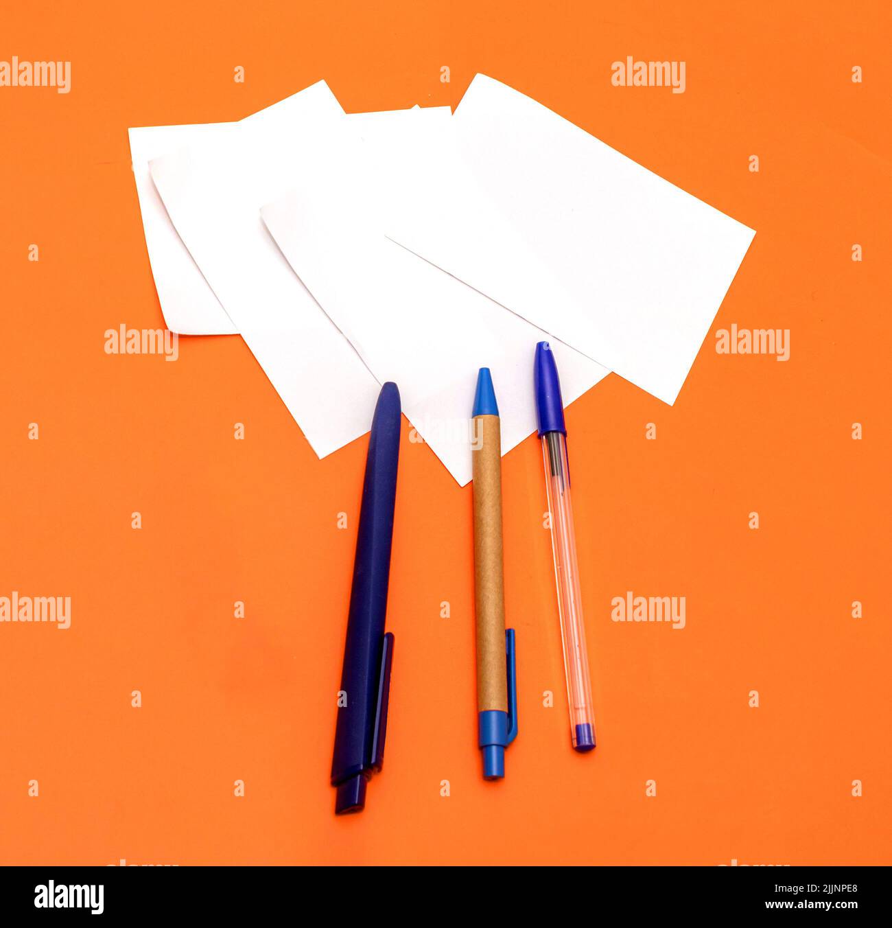 Blue corporate stationery pens on blank white paper notes for company