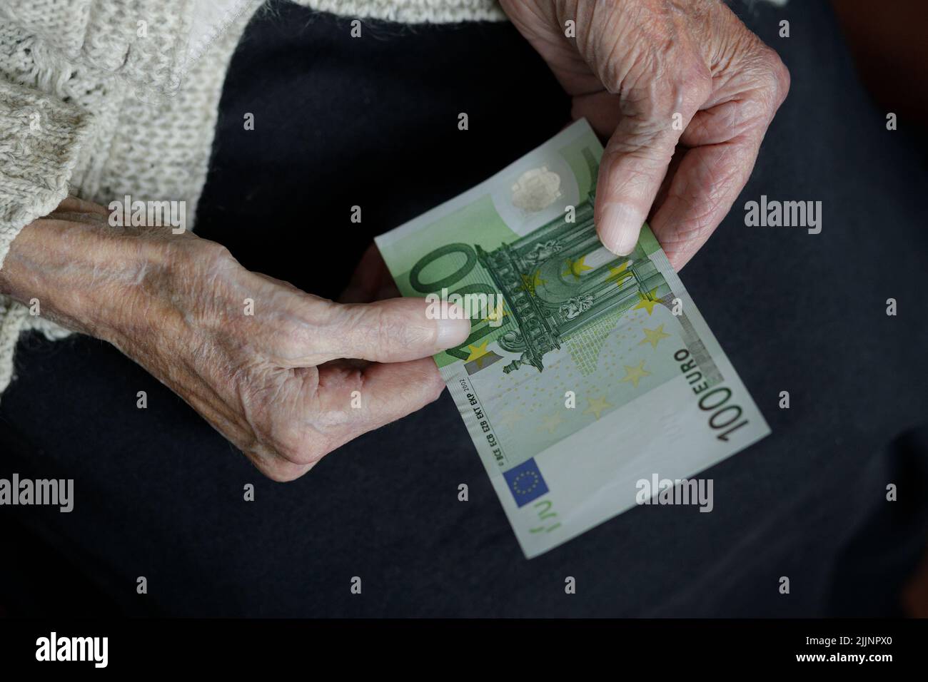Female hands hold one hundred euros. Pension, poverty, social problems and the topic of old age. preservation. Stock Photo