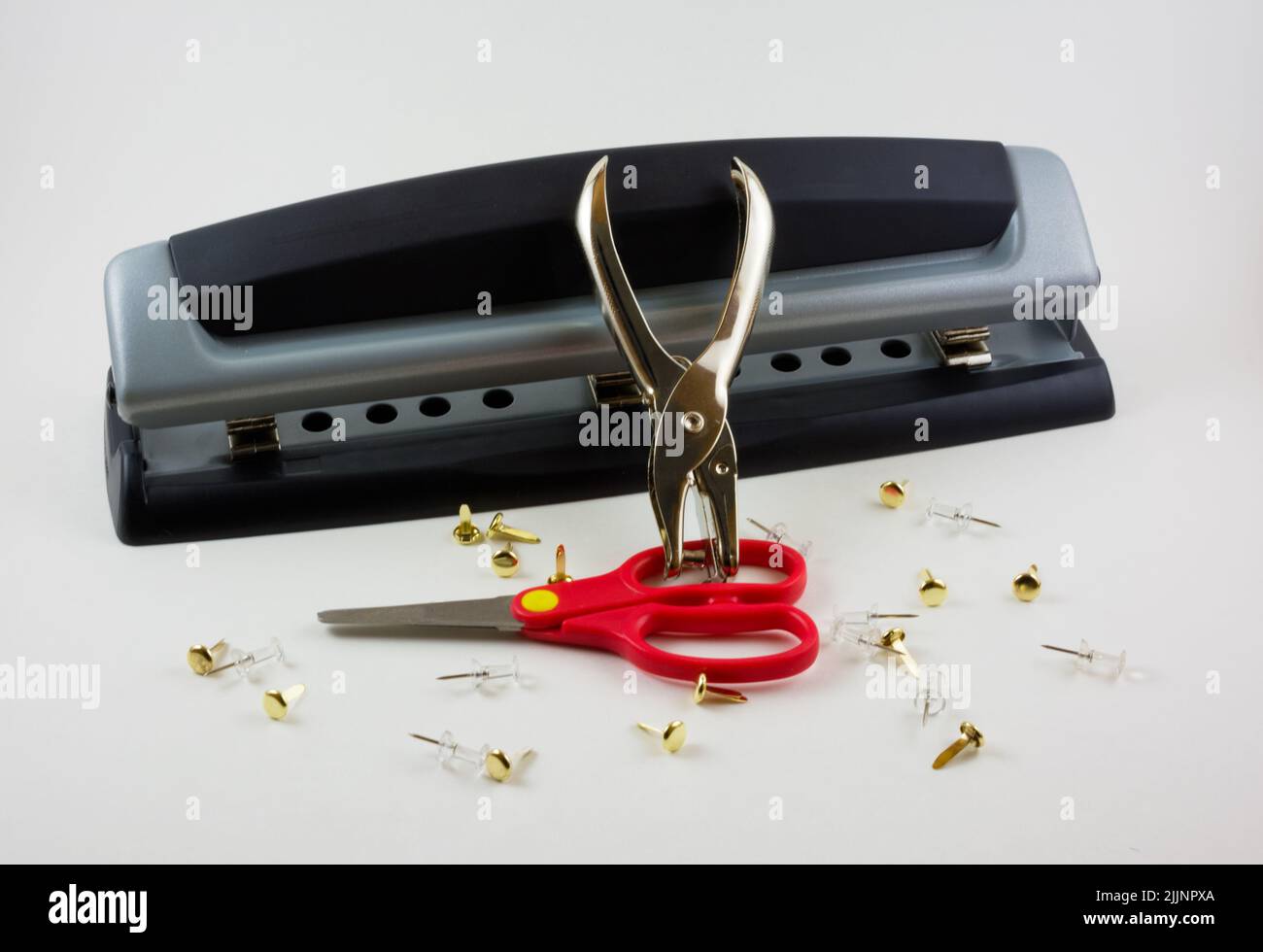 A closeup shot of desktop hole puncher and scissors isolated on white background Stock Photo