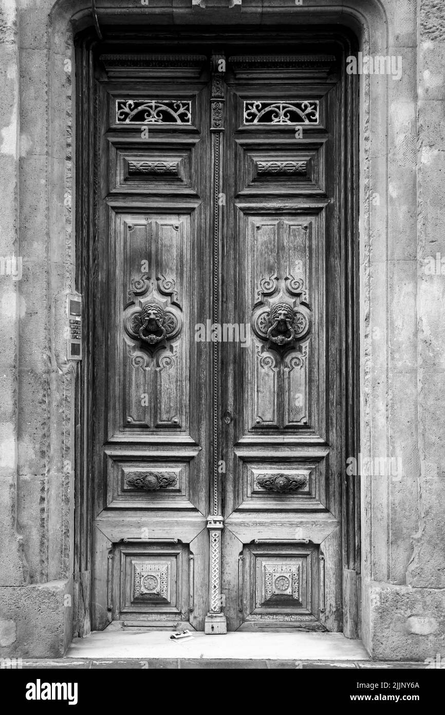 Old wooden door and vintage lion face shaped knocker in Spain Stock Photo