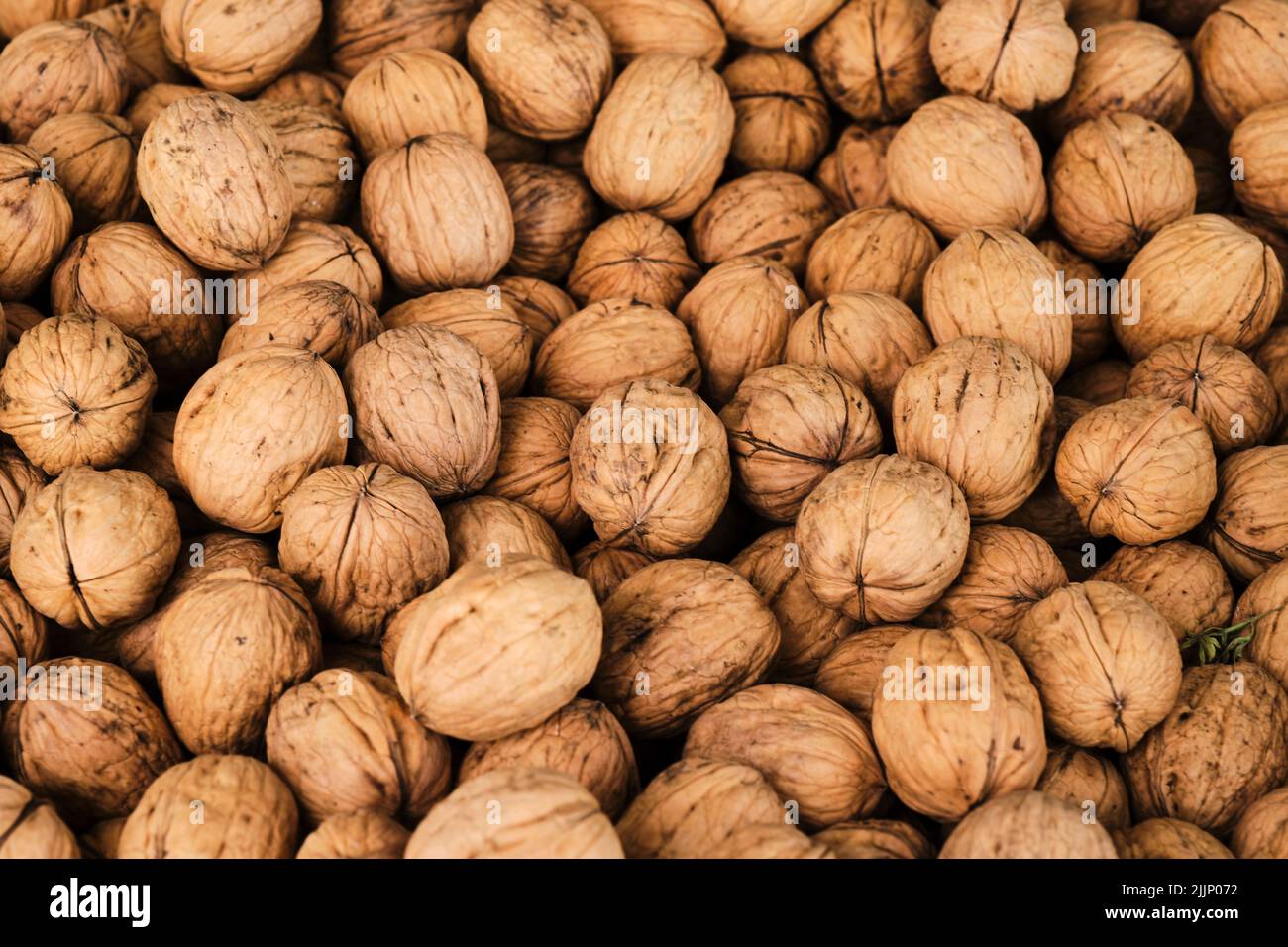 Top view of full frame background of dried walnuts in shell placed on counter at local market Stock Photo