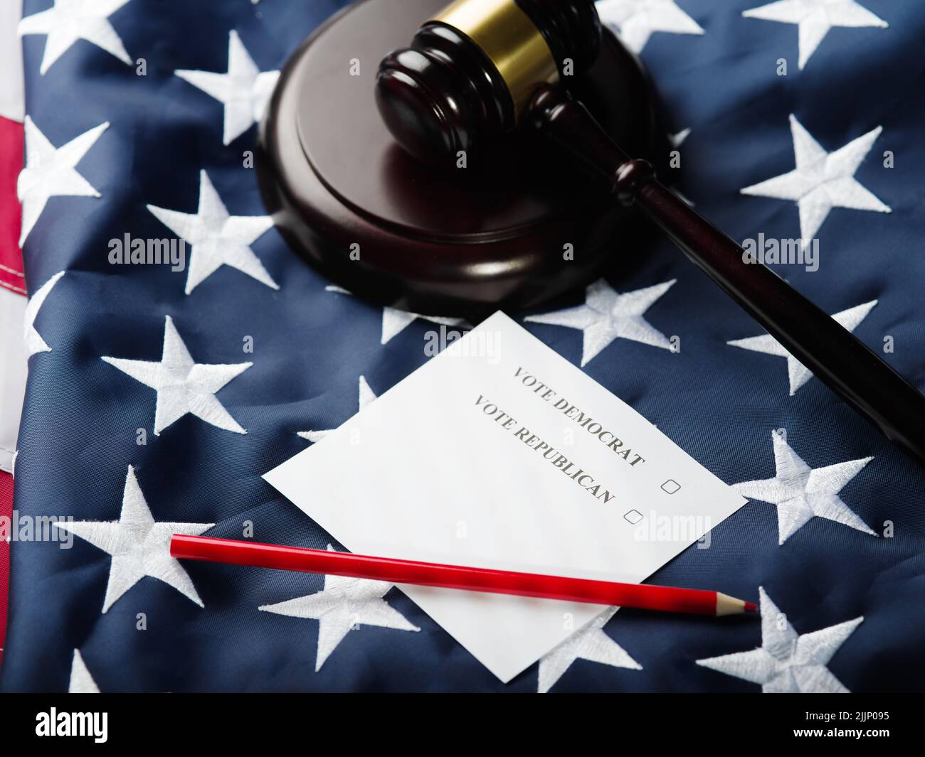 Against the background of the American national flag, a piece of paper with the inscriptions vote democrat and vote republican, a red pencil and a woo Stock Photo