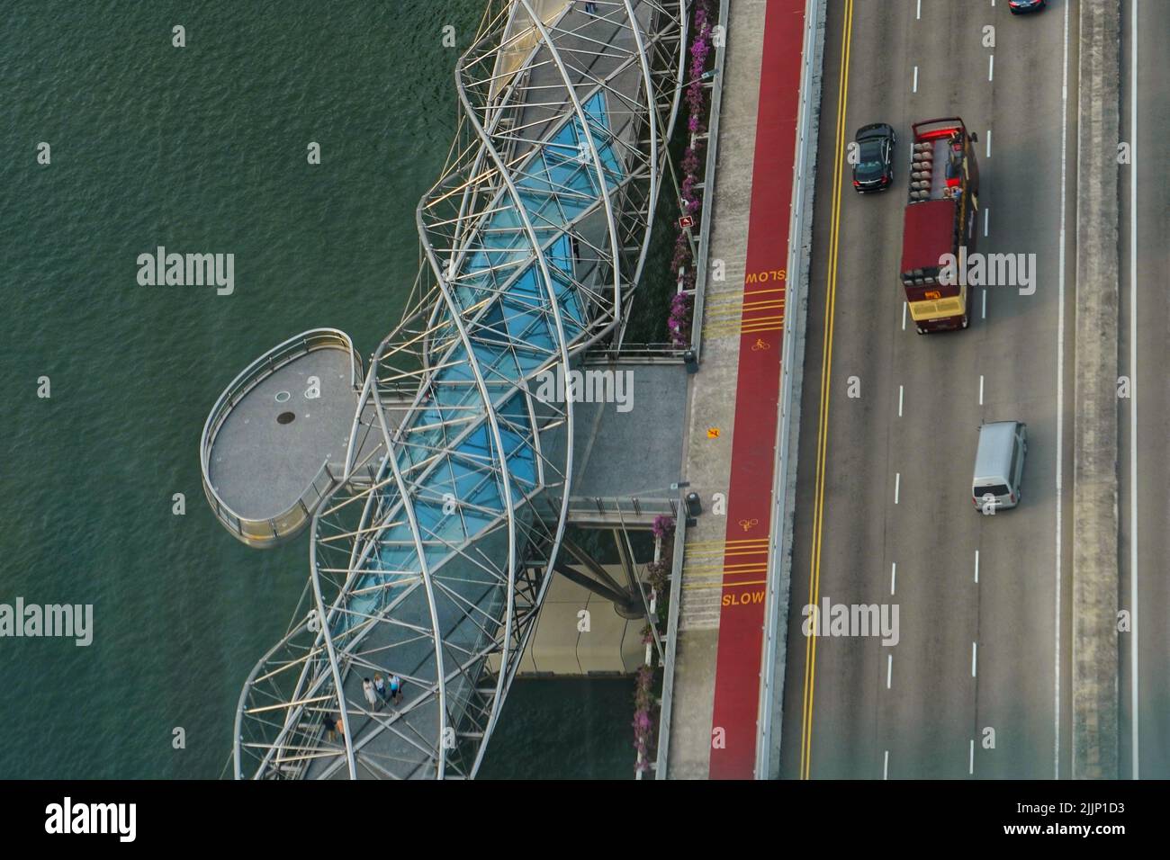A high angle shot of the streets at Marina Bay Garden in Singapore with cars driving on the road surrounded by clear waters Stock Photo